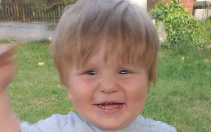 Mały chłopiec z uśmiechem, radosny moment na świeżym powietrzu.