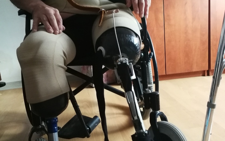 Osoba w wózku inwalidzkim z protezą nogi.
