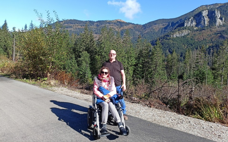 Para na wózku inwalidzkim w górach, w pięknej scenerii.