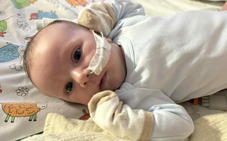 Noworodek leżący na poduszce z rurką tlenową.