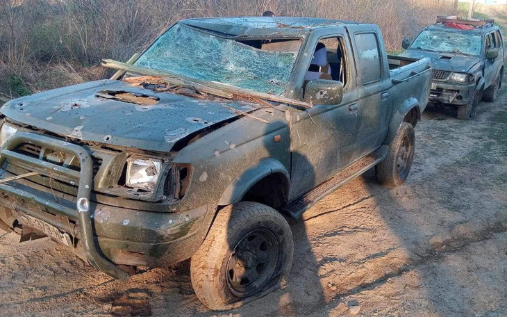 Zniszczony samochód terenowy na nieutwardzonej drodze.