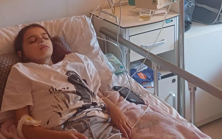 Dziewczyna leżąca w szpitalnym łóżku, podłączona do aparatury.