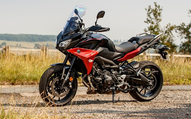 Motocykl na tle zielonego krajobrazu, idealny do jazdy w plenerze.