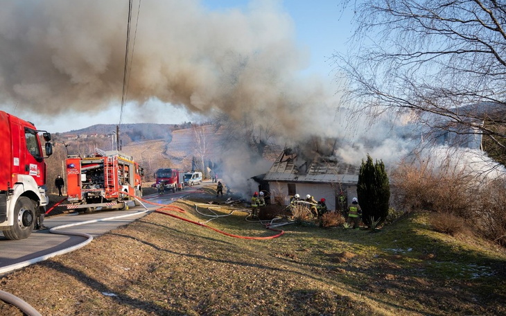Pożar budynku, strażacy walczą z ogniem w trudnych warunkach.