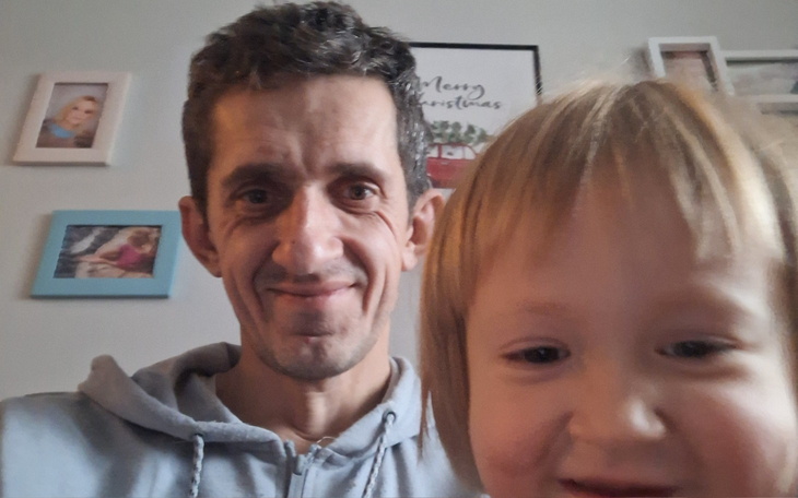 Mężczyzna z dzieckiem, oboje uśmiechnięci na selfie.