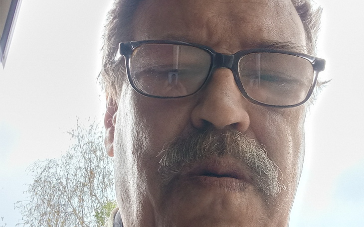 Mężczyzna w okularach, z bliskim ujęciem twarzy.