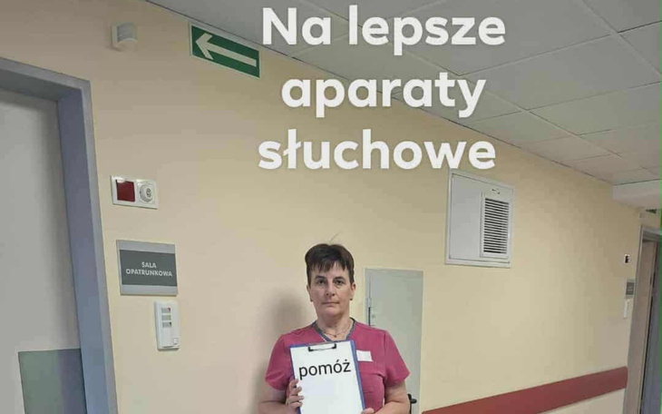 Kobieta trzymająca tabliczkę z napisem 'pomóż' w szpitalu.