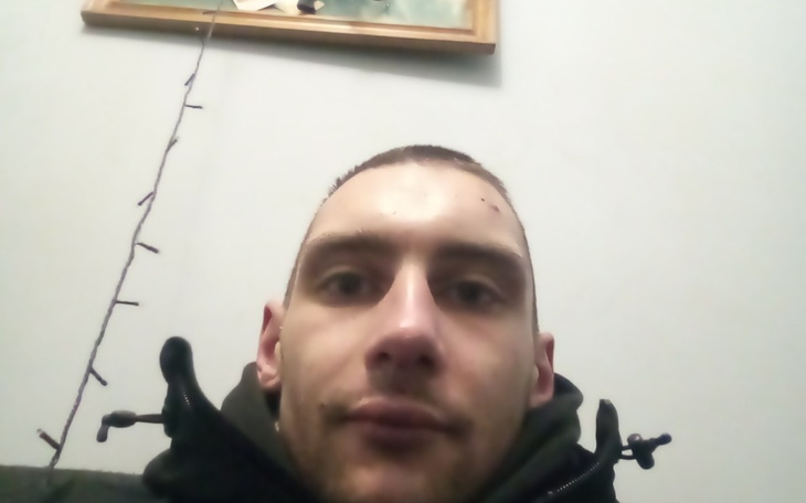 Mężczyzna w kurtce, siedzący na kanapie.