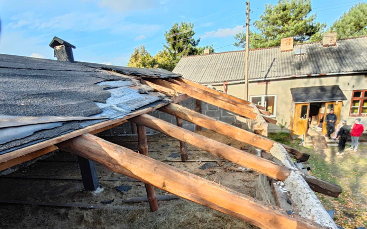 Zniszczony dach budynku, widok na podwórko.