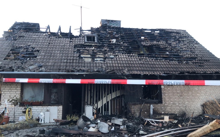 Zniszczony dom po pożarze, z widocznymi uszkodzeniami dachu.