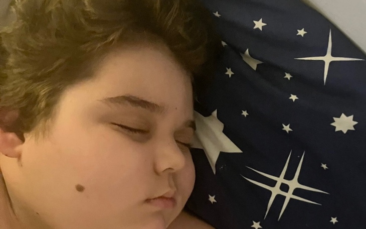 Chłopiec śpiący na poduszce, spokojny moment.