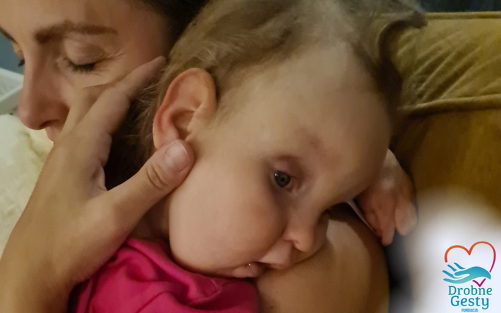 Matka przytula dziecko, oboje wyglądają na szczęśliwych i zrelaksowanych.