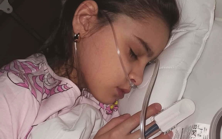 Dziewczynka śpiąca w szpitalu z tlenem.