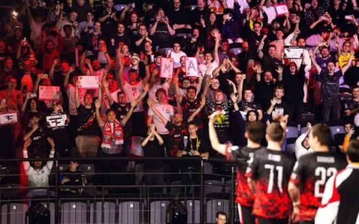 Tłum kibiców na wydarzeniu sportowym, z transparentami.