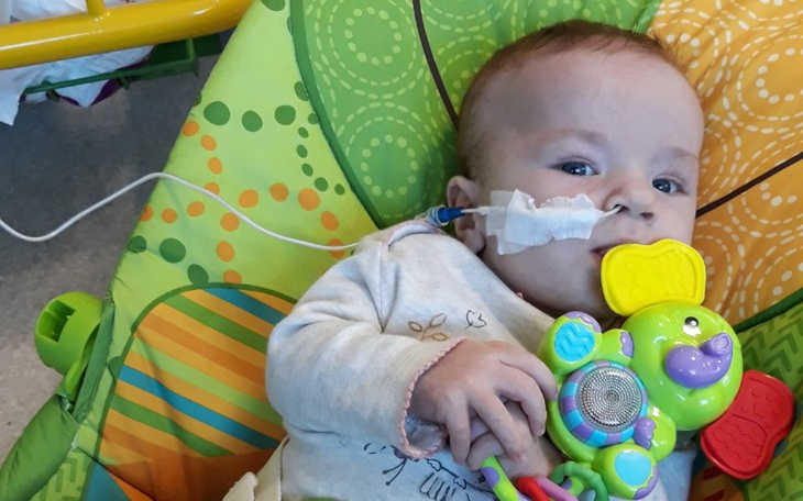 Małe dziecko w szpitalu z zabawką w ręku.