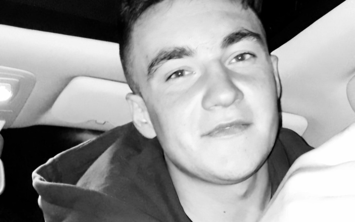 Młody mężczyzna w samochodzie, uśmiechający się.