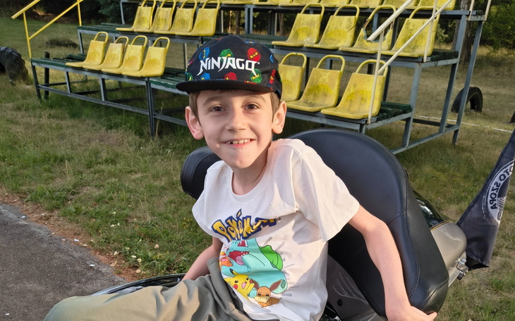 Chłopiec uśmiechający się na motorze.