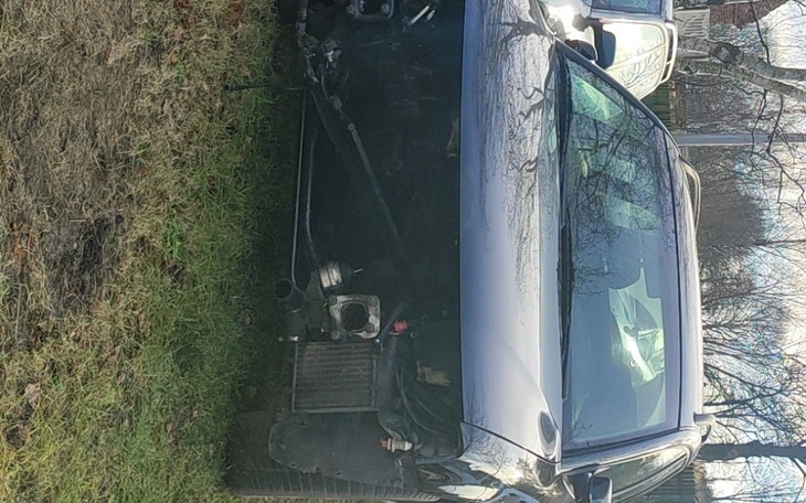 Zniszczony samochód zaparkowany na trawie.