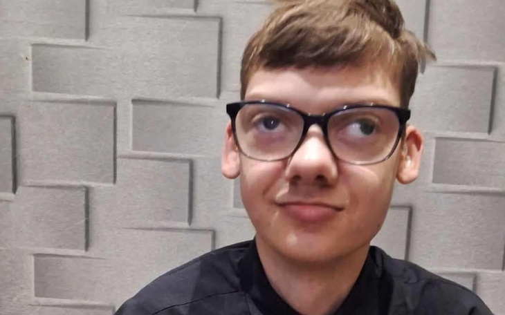 Młody mężczyzna w okularach, z nietypowym wyrazem twarzy.