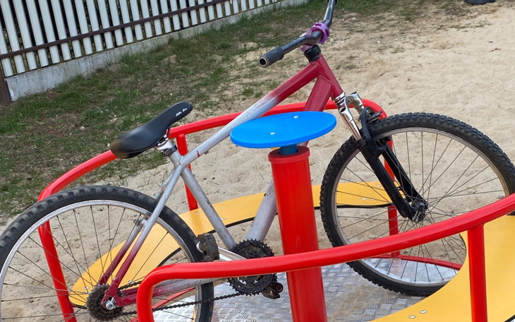 Rower na placu zabaw, stojący na karuzeli.