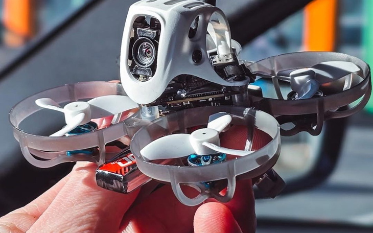 Mały dron w ręce, gotowy do lotu.