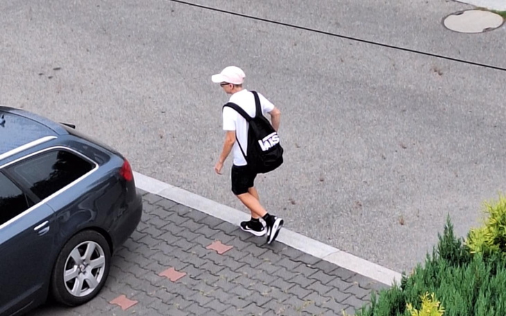 Chłopak idący ulicą z torbą na plecach.