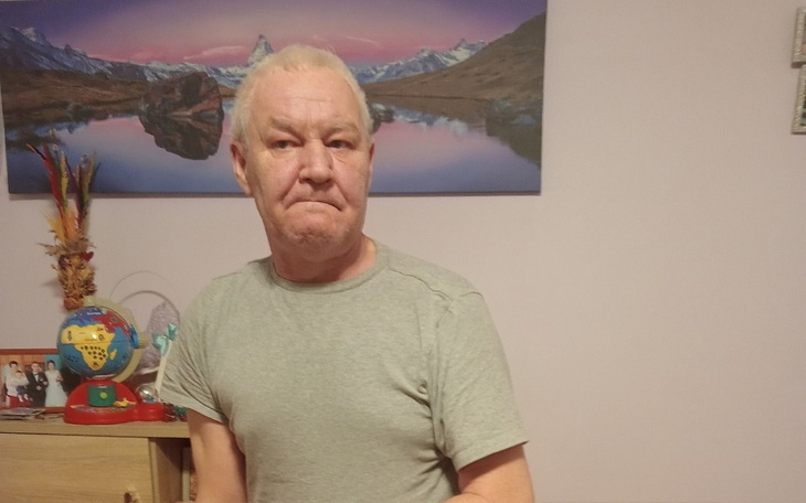 Mężczyzna siedzący w pokoju z widokiem na góry.