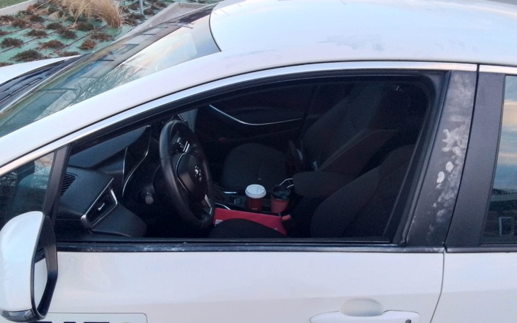 Widok wnętrza samochodu z kubkami na konsoli.