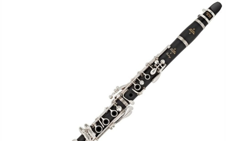 Klarinet w pozycji pionowej, na białym tle.