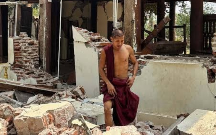 Mężczyzna w szatach mnicha w zniszczonym budynku.