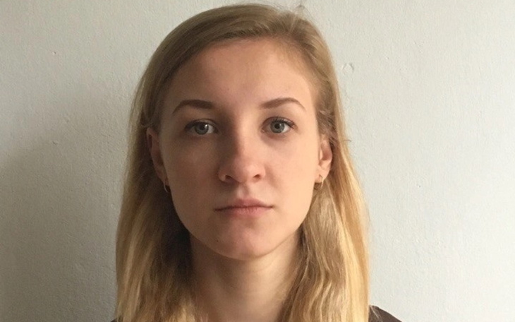 Portret młodej kobiety z poważnym wyrazem twarzy.