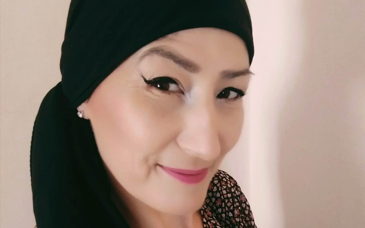 Kobieta w chustce, uśmiechająca się do kamery.