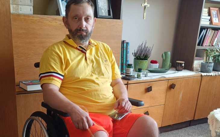 Mężczyzna na wózku inwalidzkim, w kolorowej koszulce.