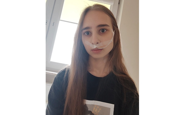 Portret dziewczyny w czarnej bluzie, z długimi włosami.