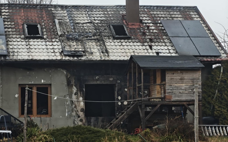 Zniszczony dom po pożarze, z uszkodzoną dachówką.