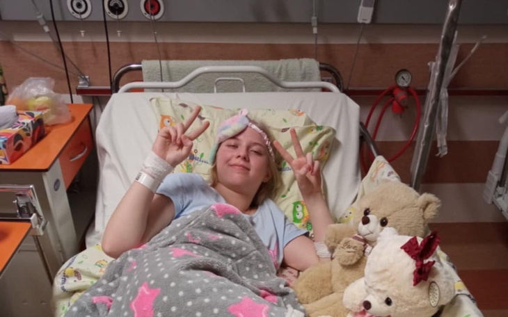 Dziewczyna w szpitalu, uśmiecha się z pluszakami.