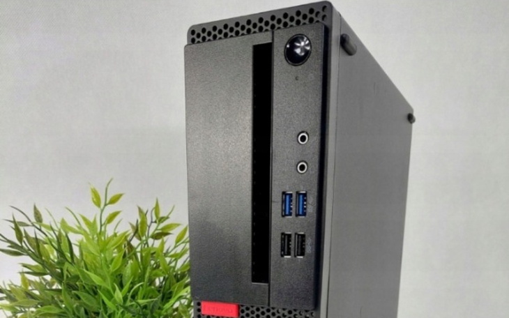 Nowoczesny komputer stacjonarny z portami USB i rośliną obok.