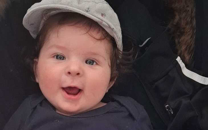 Uśmiechnięte niemowlę w czapce.