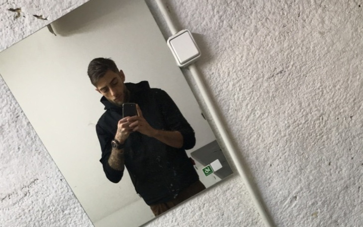 Mężczyzna robiący selfie w lustrze.