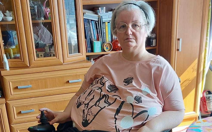Kobieta na wózku inwalidzkim w domowym otoczeniu.