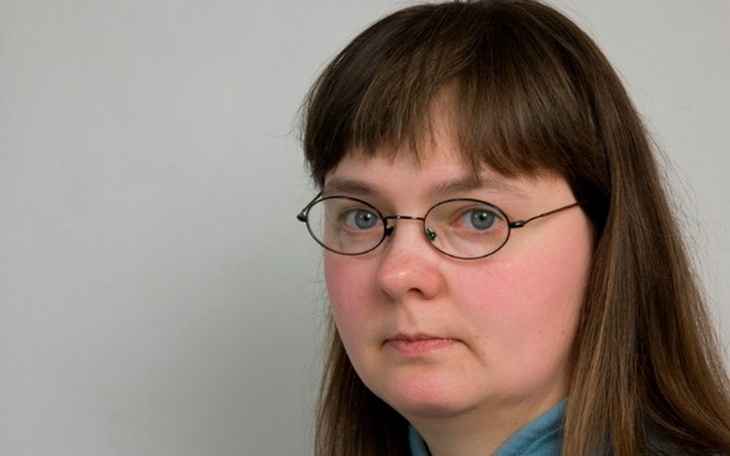 Portret kobiety z okularami, patrzącej w obiektyw.