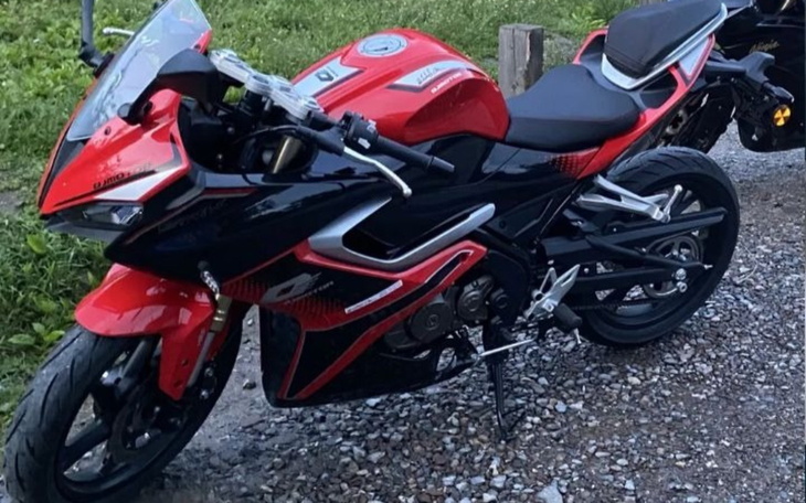 Sportowy motocykl w czerwono-czarnym kolorze na drodze.