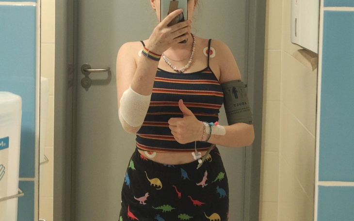 Osoba w szpitalu, pokazująca opatrunki i monitor.