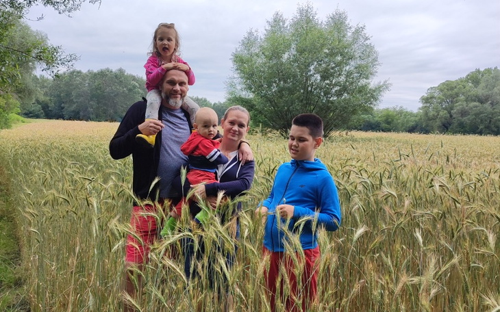 Rodzina w zbożu, ciesząca się wspólnym czasem na świeżym powietrzu.