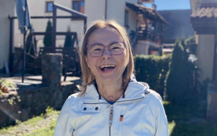 Uśmiechnięta kobieta w białej kurtce.