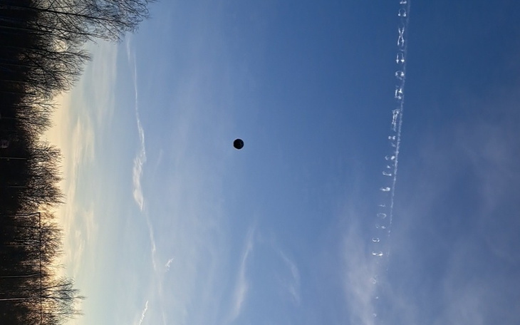 Obraz nieba z chmurami i piłką w powietrzu.