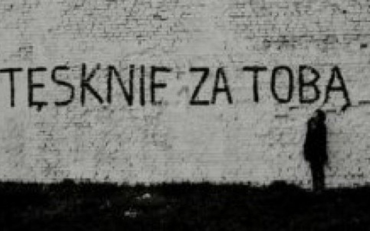Mur z napisem 'Tęsknię za Tobą' w czarno-białej tonacji.