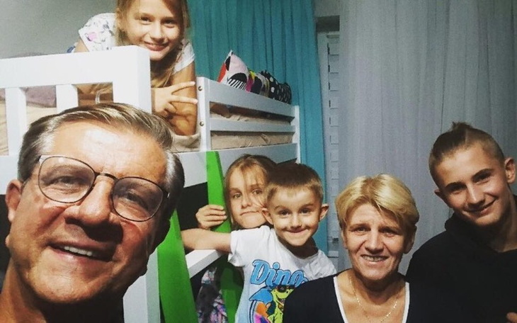 Rodzina pozująca do zdjęcia w przytulnym wnętrzu.