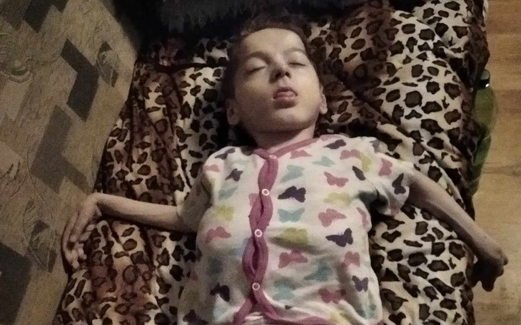 Dziecko leżące na kanapie, z językiem na zewnątrz.