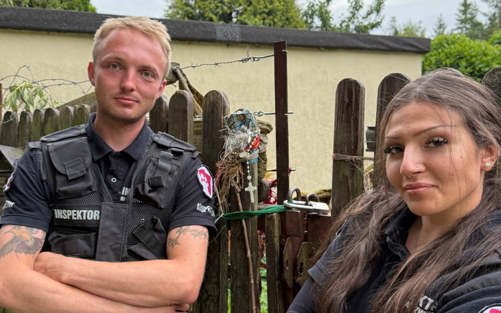 Młoda para inspektorów przy ogrodzeniu, gotowa do działania.